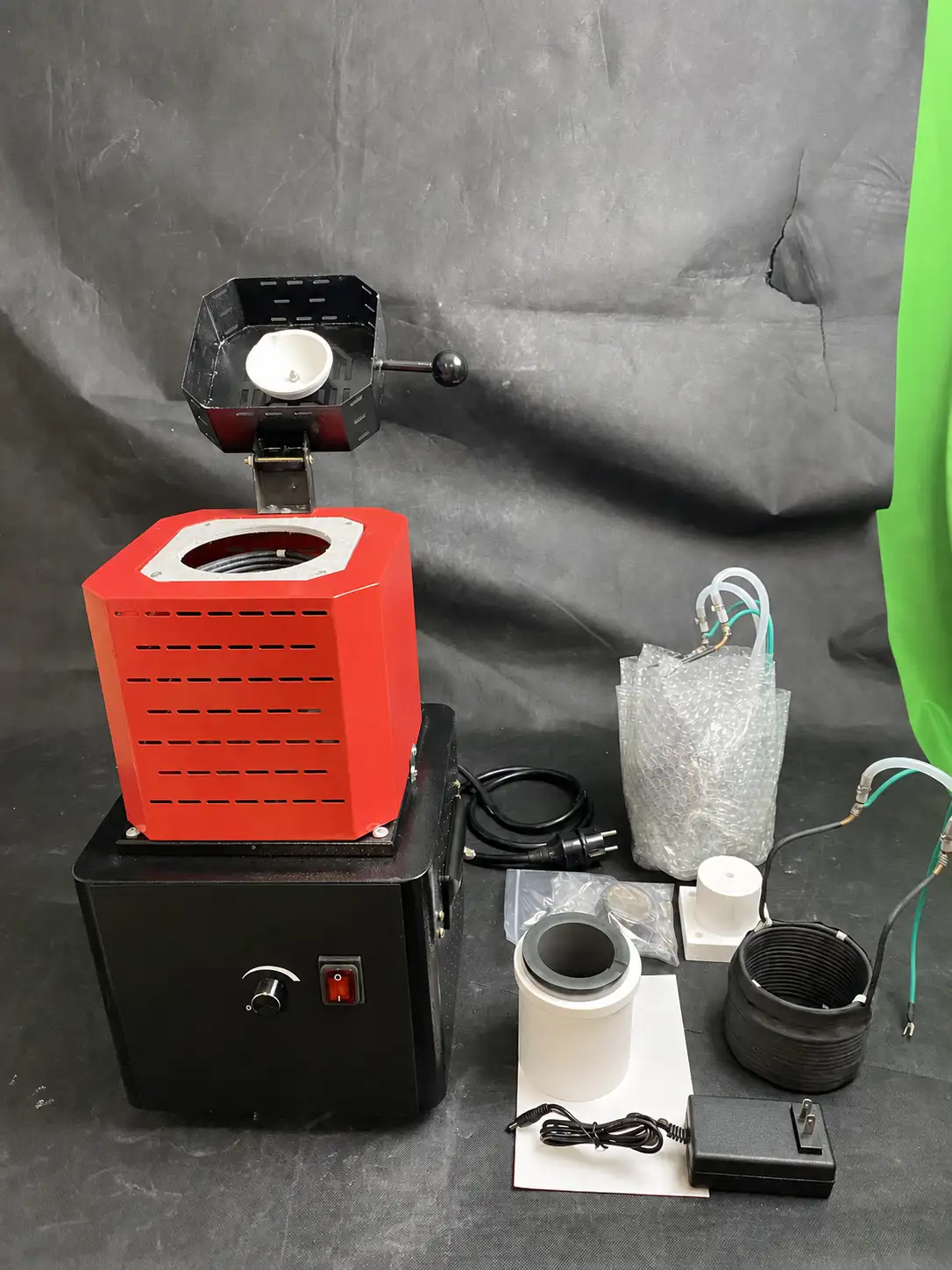 Compact open induction melting furnace with tilting crucible holder, coil, cooling circuit and accessories