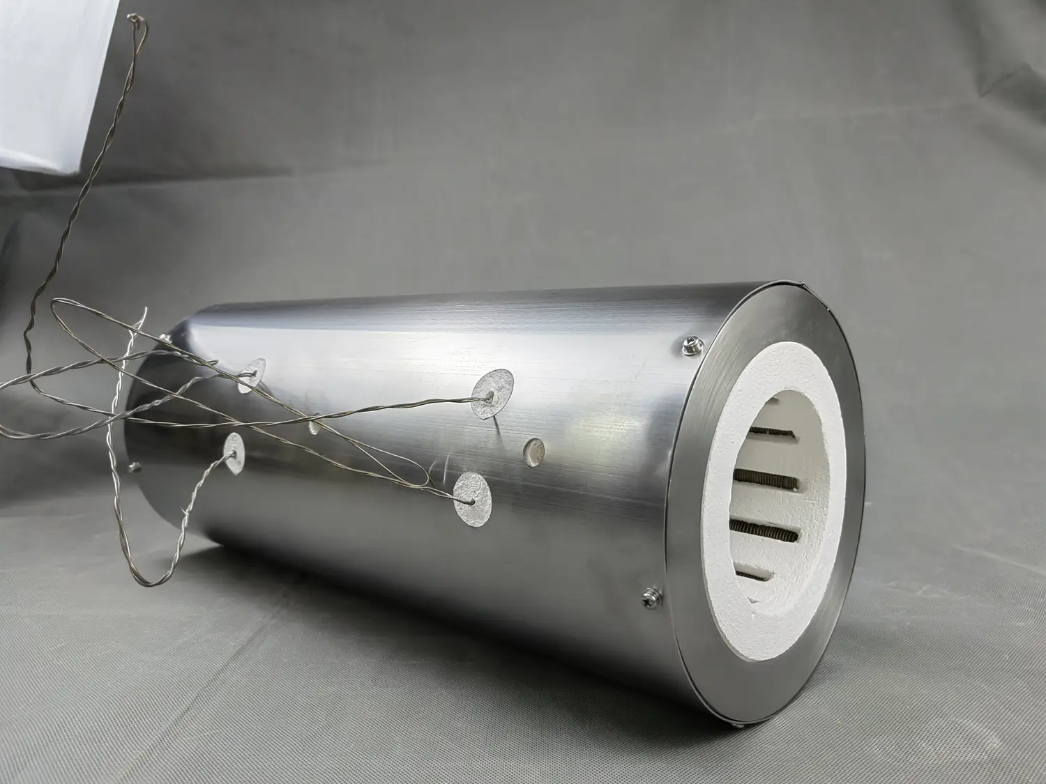 Cylindrical metal-shelled heated chamber showing the outer enclosure and service leads