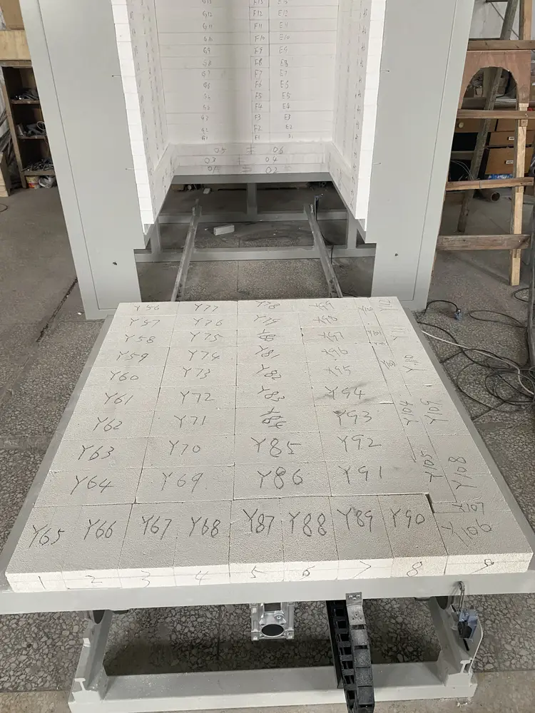 Rail-guided mobile refractory hearth positioned in front of a trolley furnace chamber