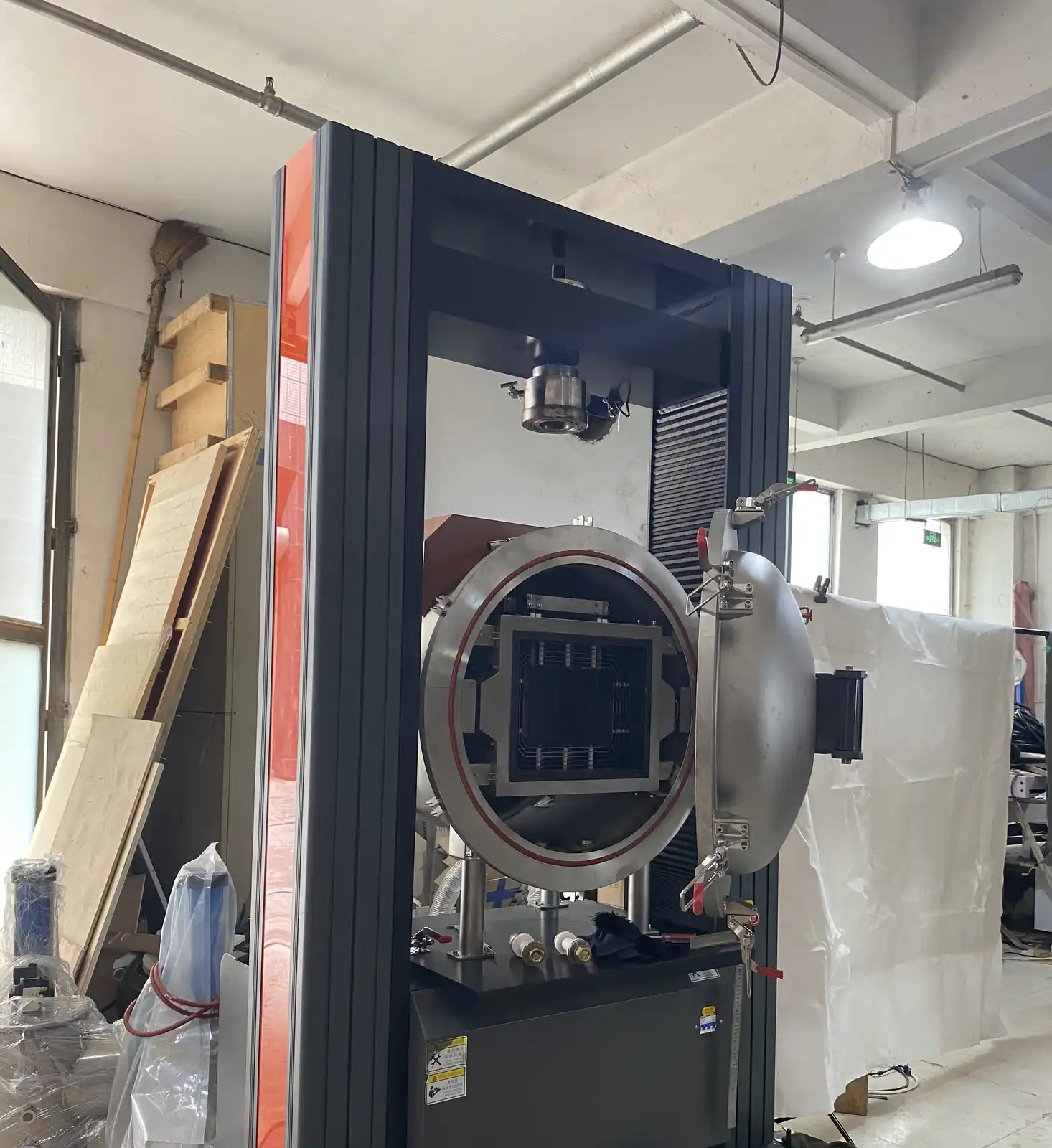 Vacuum hot press furnace with pressure frame, open process vessel and internal heated zone